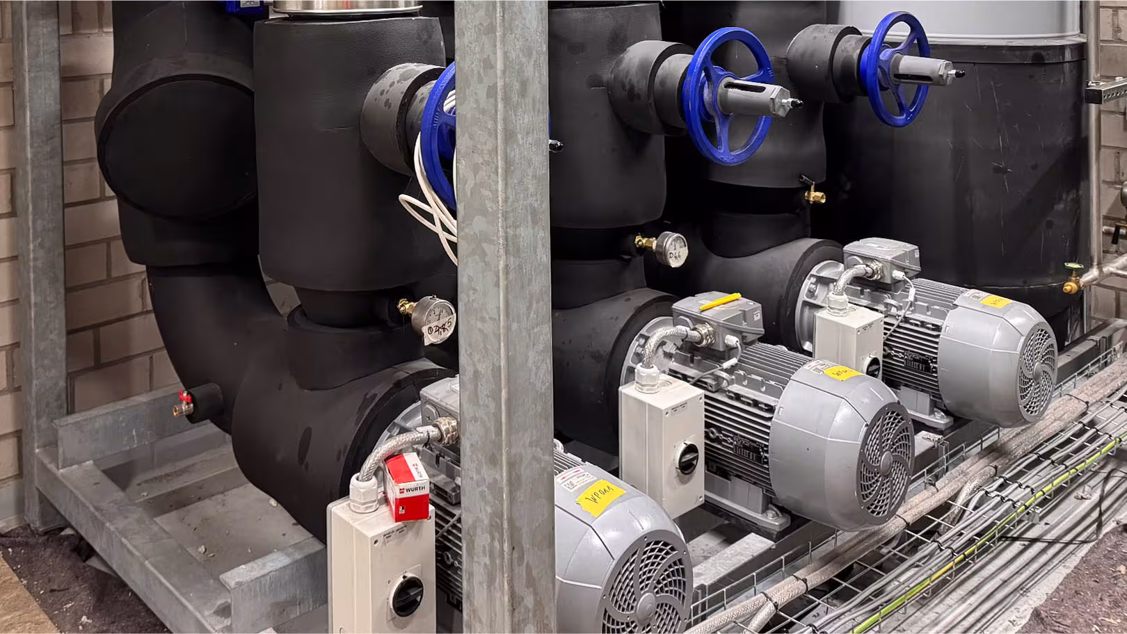 Detailaufnahme isolierter Aggregate und Pumpen mit dampfdichter Kautschuk-Kälteisolierung im Tiefkühllager