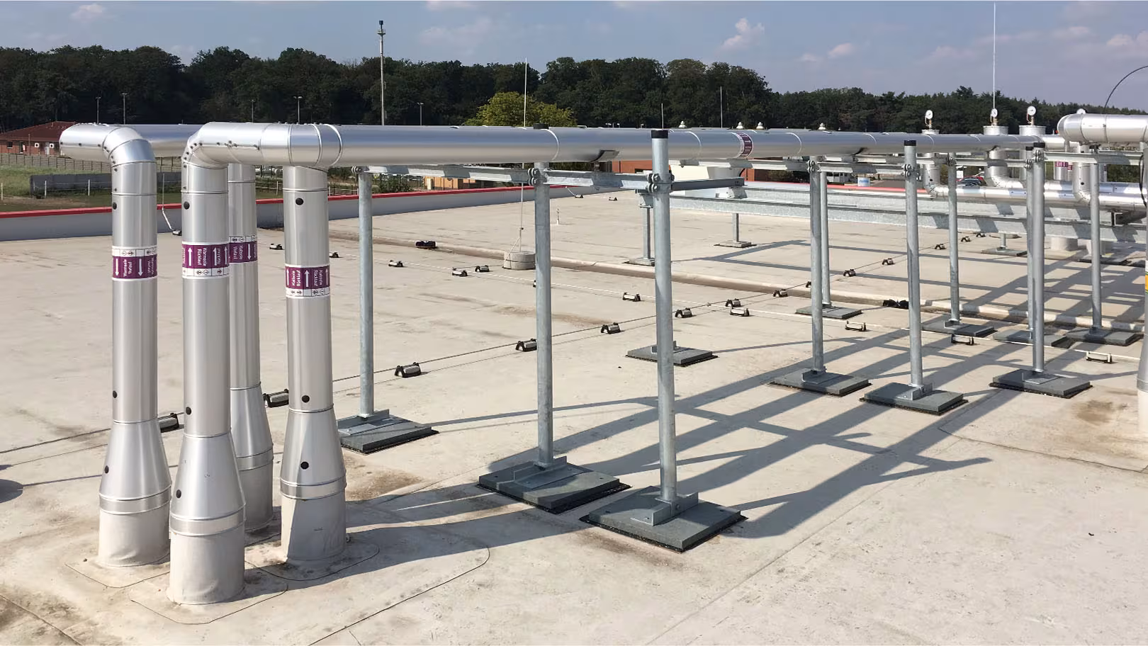 Auf dem Dach verlegte Vor- und Rücklaufleitungen mit Aluminium-Mantel und Kennzeichnungsbändern